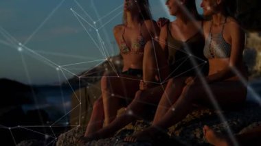 Üç kadın kayalık sahil günbatımında oturuyor, şeffaf şebeke ile teknolojik bağlantıyı ortaya çıkarmak için yanıp tutuşuyor. Arkadaşlık, rahatlama, açık hava, huzur, dostluk, bağlantı, atmosfer.