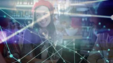 Tablet tutucu, kafeterya tablosunda ekranı gruba doğru eğerek, canlı ağ örtüsü çiziyor. İşbirliği, ağ oluşturma, iletişim, dijital, teknoloji, sosyal, gündelik.