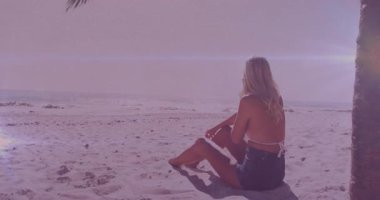 Bir kadın akıllı telefonu geri alıyor ve güneş ışığının altında denize bakarken iş görüşmesi yapıyor. Sahil, sükunet, rahatlama, rahatlık, cazibe, açık hava, yaşam tarzı.