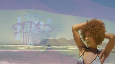 Akıllı telefonları hizalayan bir arkadaş, pazarlama için solmuş İspanyol bayrağı altında sahilde poz veren bir kadın yakalıyor. Sahil, eğlence, canlı, açık hava, neşeli, yaşam tarzı, yaz