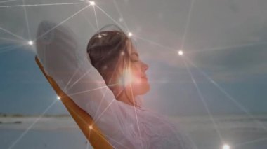 Kadın, okyanus kaymasına karşı yaslanan koltuğa yaslanıyor ve göğüs çevresinde titreşimli küre oluşturuluyor. Teknoloji, bağlantı, yenilik, dinginlik, gelecekçilik, refah, dijital