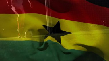 Futbolcu bacakları dürtüklüyor sonra topa vuruyor ve saydam Gana bayrağı ile topa vuruyor. Sporcu, spor, aksiyon, yarışma, stadyum, çim, çeviklik