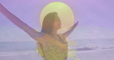 Kadın kıyı şeridinde morarmış filtre altında sağlık esnemesi başlatıyor, havada süzülen güneş grafiğini canlandırıyor. Rahatlama, dinginlik, kıyı, farkındalık, doğa, pastel, meditasyon