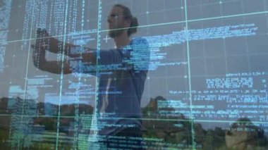 Telefonu tutan kullanıcı holografik ızgarayı başlatıyor, teknoloji kod incelemesi için kod panellerini sürüklüyor. Güçlendirilmişlik, fütüristik, yenilik, dijital arayüz, teknoloji, açık hava, jest denetimi