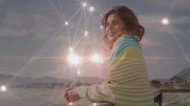 Deniz kenarındaki korkuluklara yaslanan kadın teknoloji ağının örtüşmesini seyrediyor sonra kayboluyor ve gülümsüyor. Düşünce, yenilik, sükunet, manzara, bağlantı, huzur, içgözlem