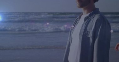 Adam kıyıda durup okyanus kadınını seyrediyor çerçeveye giriyor el ele tutuşuyor seyahat reklamı için kollarını sarıyor. Huzur, bağlantı, romantizm, şafak, ahenk, farkındalık, arkadaşlık