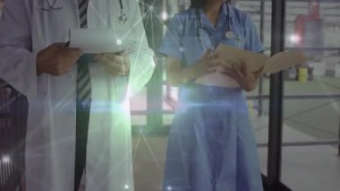 Doktor ve hemşire, klinikte ağ bağlantısı kurulduktan sonra dosyaları inceleyip kayıtları güncelliyorlar. Tıbbi personel, hastane, klinik, takım çalışması, sağlık hizmetleri, modern, profesyonel