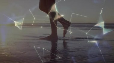 Sahile gidenler ıslak kumda ağırlıklarını değiştiriyor. Teknoloji gösterisi için dönen küre oluşturuyorlar. Manzara, fütürizm, bağlantı, dijital alarm, macera, yenilik, huzur