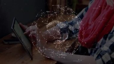 Kadın tablet ekranını tıklatıyor ve araklıyor ve çalışma alanının üstünde dönen teknoloji veri küresini keşfediyor. Teknoloji, yenilik, dijital, bağlantı, modern, çalışma alanı, fütürist