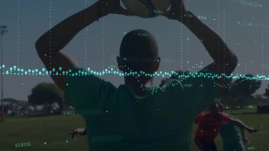 Teal-üniformalı futbolcu top kaldırıyor, top fırlatıyor, rakiplerinin yanından geçip gidiyor. Sporcular, spor, aksiyon, açık hava, rekabetçi, takım çalışması, atletizm