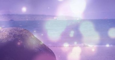 Başlangıçta mor ve beyaz bokeh küreler rüya gibi plaj örtüsü için kayaların ve okyanusların üzerinde sürükleniyordu. Huzur, sükunet, doğal, ruhani, düşünceli, soyut, minimalist.