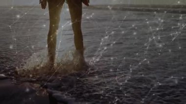 Dalgalar ayak bileklerini bükerken sörf yapan kadın kameranın çekilmesine ve teknoloji ağının örtüşmesine neden oluyor. Sahil, sahil, gün batımı, dinginlik, bağlantı, dijital, sükunet