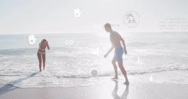 Kadın sığ sörflere adım atıyor ve adam geriye yaslanıyor seyahat reklamında oynarken su sıçrıyor. Deniz manzarası, çift, neşeli, susuz, boş, enerjik, romantik