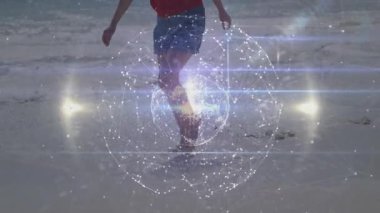 Sahilde yürüyen bir kadın, üç boyutlu bir küreyi döndürüyor ve çalıştırıyor. Ağ ışıkları yanıp sönüyor. Futuristik, teknoloji, bağlantı, dijital, yenilik, gevşemiş, manzaralı