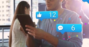 İş arkadaşları haber verildikten sonra tableti tıklatıyor ve yüzen kabarcıklarla sosyal medya istatistiklerini izliyorlar. İşbirliği, iletişim, teknoloji, çalışma alanı, dijital, modern, üretkenlik