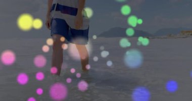 Plaj suyuna adım atan ve renkli daireler çizerken sağlık testleri için denge kuran bir adam. Deniz kenarı, hareket, sükunet, dinginlik, farkındalık, akıcılık, rahatlama