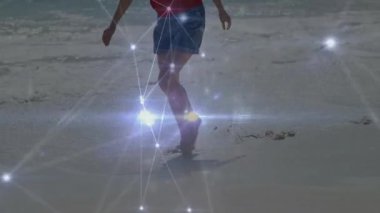 Kıyı boyunca çıplak ayakla yürüyen bir kadın ıslak kumun üzerine basıyor ve titreşimli teknolojiyi aktifleştiriyor. Plaj, bağlantı, dijital, boş zaman, modern, huzur, doğa