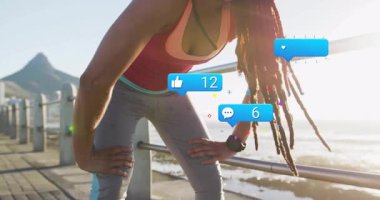 Akıllı twatch 'e bakan, deniz kenarına koşan bir kadın bağlandığını gösteren animasyon sosyal ikonlarına bakıyor. Sporcu, fitness, outdoor, motivasyon, digital, technology, wellness