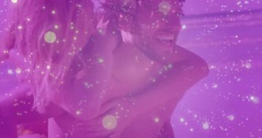 Mor sis soluyor ve kadını sırtında taşıyan bir adam hayat tarzı reklamı için kıyıda geziniyor. Romantizm, çift, plaj, güneş ışığı, neşeli, mutluluk, sükunet