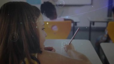 Sarışın kız okulda esmerlere sır fısıldıyor, kalem yazma dijital diyagramları dolduruyor. İşbirliği, arkadaşlık, iletişim, eğitim, gençlik, dijital, yenilik