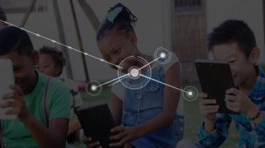 Çocuklar tabletleri bankta tutuyor, bağlantı kurmak için eğitim ağını genişletmeye çalışıyorlar. Çocuklar, teknoloji, bağlantı, dijital, açık hava, öğrenme, işbirliği