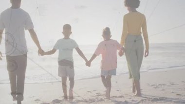 Aile gün batımına doğru sahilde el ele yürürken seyahat reklamı için nemli ayak izleri bırakıyor. Aileler, birliktelik, açık hava, manzara, macera, tasasız, nostaljik