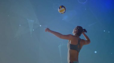 Voleybol oyuncusu topu atıyor ve spor teknolojisi için plajda servis yapıyor ve veriler yoğunlaşıyor. Atletik, spor, dijital, yenilik, açık hava, performans, çağdaş