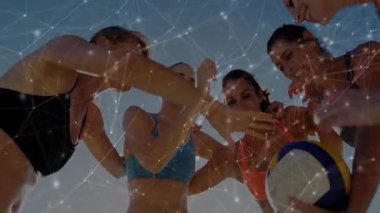 Şarkı söyleyen takım arkadaşları maçtan önce plajda voleybol oynuyorlar ve birlik oluşturuyorlar. Takım çalışması, yoldaşlık, birlik, rahatlık, rahatlama, canlı, açık hava.