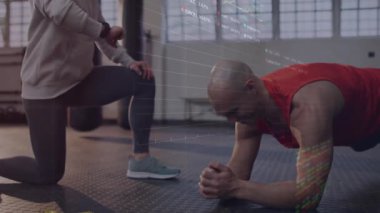 Fitness antrenörü, sistem ölçüm çizelgesi oluştururken elinde tahta tutan akıllı adam rehberliği yapıyor. Güç, ilerleme, koçluk, biyometrik, eğitim, yenilik, sağlık