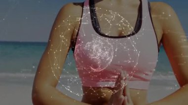 Dişi yogi dua eden, parlayan dünyayı çağıran, okyanus kıyısındaki pembe minderde sağIık için mudra oluşturan. Meditasyon, dinginlik, farkındalık, ruhsal huzur, huzur, doğa, rahatlama