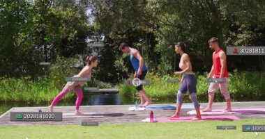 Tahta platformda yürüyen dört yetişkin yoga minderlerini açıyor ve yüzen fitness verilerini sergiliyor. Sağlık, açık hava, egzersiz, farkındalık, denge, veri, birlik