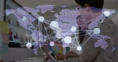 Tableti tıkırdatan kadınlar renk çarkını ayarlayan şeffaf dünya haritasını canlandıran bilgilendirme tasarımı sergilerler. İşbirliği, dijital, yenilik, bağlantı, küresel, teknoloji, analiz