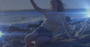 Oturan ve telefon kaldıran bir kadın selfie çekiyor, canlandırılmış lensler sosyal medyayı canlandırıyor. Sahil, huzur, manzara, boş zaman, açık hava, yansıtıcı, canlı