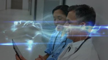 Hemşire tableti tıkırdatıyor ve hastane koridorunda holografik çizelge üzerinde çalışıyor. Tıbbi, teknoloji, yenilik, sağlık, fütürizm, işbirliği, dijital