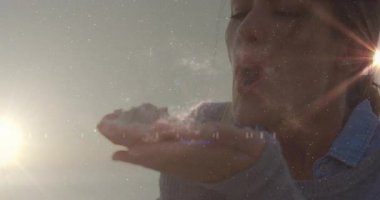 Avuç içi kaldıran, günbatımı denizi üzerinde kum bulutu üfleyen bir kadın seyahat pazarlaması için animasyon güneş patlaması yapıyor. Dinginlik, rahatlama, doğa, farkındalık, ortam, sükunet, rahatlık