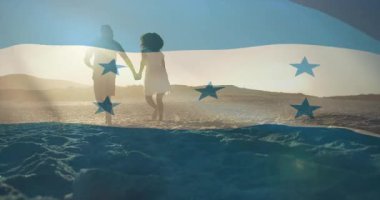 Dalgalı Honduras bayrağı siluetleri gösteriyor, çiftler turizm için sahil gün batımında el ele yürüyorlar. Vatanseverlik, birlik, sükunet, romantizm, manzara, eğlence, ahenk