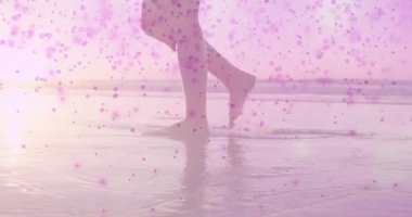 Çıplak ayakla suya adım atan, sağIık için pembe benekler altında hafif dalgalanan bir kadın. Dinginlik, sükunet, manzara, rahatlık, minimalizm, rahatlama, doğal