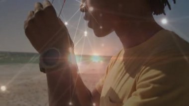 Ufuk manzarası için plajda güneş gözlüğüne uzanan adam titreşen teknolojiyi devreye sokuyor. Teknoloji, bağlantı, açık hava, eğlence, yenilik, keşif, modern