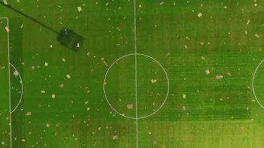 Konfeti sürükleniyor ve zum çemberinden fırlıyor, projektör ışığı gölgesini ortaya çıkarıyor ve duruyor. Stadyum, kutlama, açık hava, panoramik, canlı, spor, atmosfer