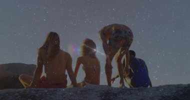 Güneş ufukta batıyor. Arkadaşların kayalık çıkıntıda kayalara kaymasına yol açıyor. Seyahat reklamı için mercek patlaması yaratıyor. Gün batımı, ufuk, arkadaşlık, açık hava, boş zaman, manzara, sükunet