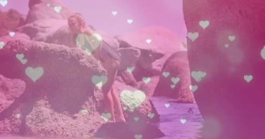 Kaya üzerinde el ele tutuşan, tırmanan ve kıyıları yüzen kalplerle tarayan bir çocuk. Macera, keşif, açık hava, doğa, esneklik, neşeli, canlı