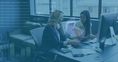 İki kadın iş masasında akıllı telefon jesti yapıyor. Monitörden animasyon çizelgelerini inceliyorlar. Profesyonel, işbirliği, modern, iş, analitik, dijital, kurumsal