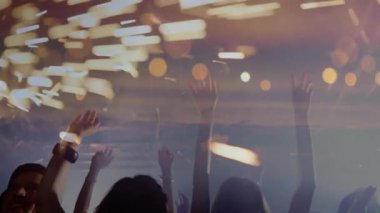 Altın bokeh kalabalığa el kaldırmaya başlıyor, değişen ışıklar altında ve düşen kıvılcımlar altında kutlama yapıyor. Kutlama, konser, gece hayatı, parti, enerji, aydınlanma, şenlikler