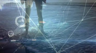 Okyanus dalgalarına adım atan ve gün doğumunda vücut eklemlerini aydınlatan dijital ağı başlatan kadın. Gelecek, sağlık, rahatlama, farkındalık, dinginlik, teknoloji, uyum.