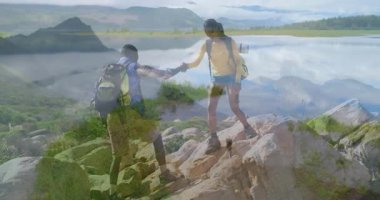 Maceraperest yürüyüşçüler tırmanma sırtı sunan adamı yakalarken yükselti de yükselişi gösteriyor. Keşif, takım çalışması, doğa, açık hava, engebeli, panoramik, başarı