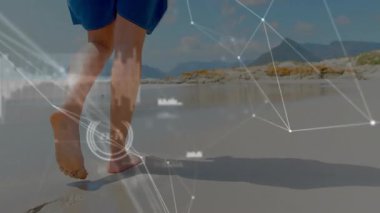 Islak kıyı şeridine adım atan bir adam yürüyüş takibi için ayakların etrafını çevreleyen teknoloji verilerini başlatıyor. Ayak izleri, kıyı şeridi, yansıma, navigasyon, analitik, açık hava, dijital