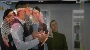 Yelekli bir adam camdan duvara çizim yapıyor. Strateji gösteriyor. Teknoloji dünyası tepemizde dönüyor. İşbirliği, beyin fırtınası, yenilik, takım çalışması, modern, dijital, iş