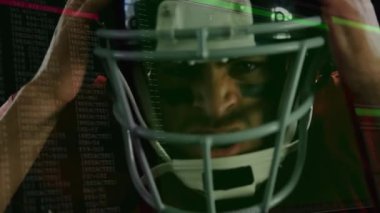 Futbolcu kaskı kaldırıyor ve ayarlıyor, dijital kod altında kayışı oyuna hazırlıyor. Sporcu, spor kıyafeti, fütüristik, performans, kararlılık, çeviklik, yenilik