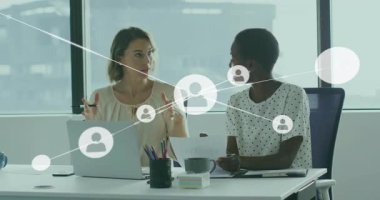 Masa başındaki iş kadınları dizüstü bilgisayarlarını açıp not alıyor, kullanıcı düğümleri büyütüyor ve beşlik çakmayı bitiriyor. İşbirliği, ağ oluşturma, takım çalışması, stil, profesyonel, iletişim, yenilik