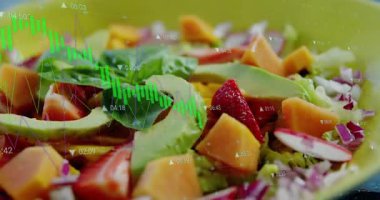 Dalga formu grafiği yeşil salata kasesinin üzerinde kayboluyor, avokado boyunca ilerliyor ve zaman kodlarını gösteriyor. Taze, sağlıklı, organik, çağdaş, canlı, dijital, besleyici